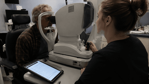 An eye care technician performs pre-surgical measurements on a patient during a toric IOL cataract surgery consultation in Louisville, KY.